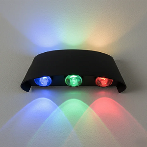 ابليك 3 عدسات RGB بجسم أسود مركّب على الحائط، إضاءة ملوّنة بارزة (أزرق/أخضر/أحمر).